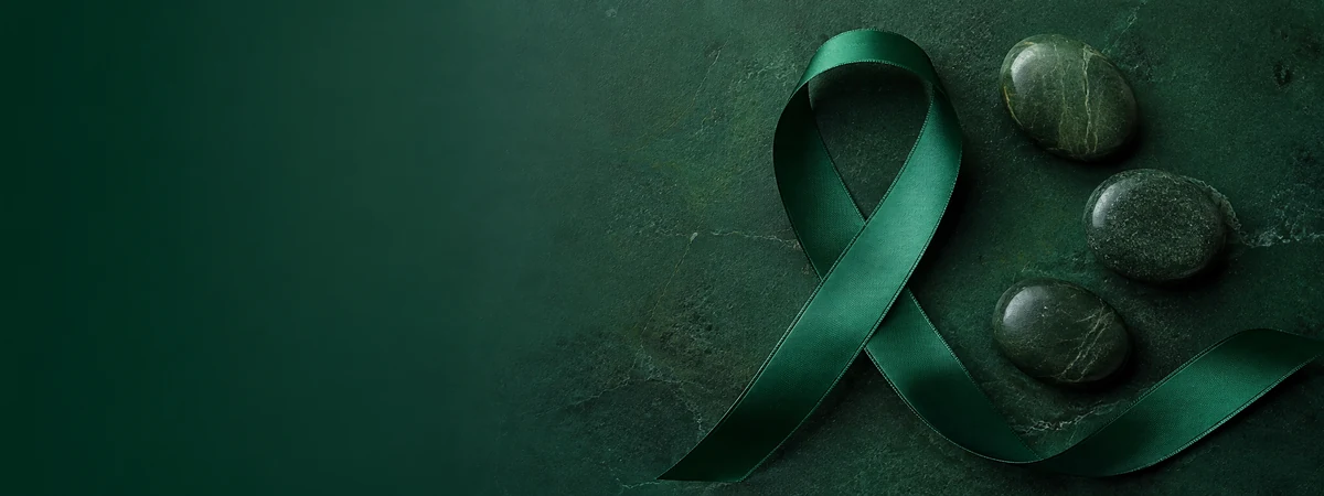 Green awareness ribbon on a dark green textured background.